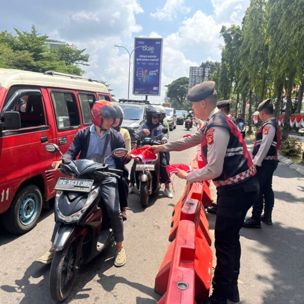 Polda Sumsel Bagikan Bendera Merah Putih Kepada Masyarakat Palembang Menyambut Hut Kemerdekaan RI Ke-80
