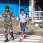 Peduli Keselamatan, Babinsa Timika Bantu Lalu Lintas Penyeberangan Anak Sekolah